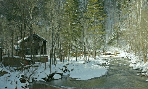 house on stream in winter